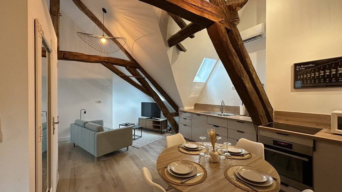 Salle à manger sous charpente apparente, appartement mansardé de Chablis, après travaux